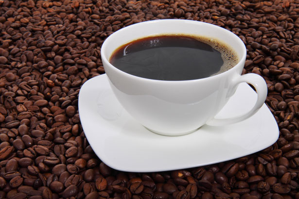 Kaffeetasse, umgeben von Kaffeebohnen